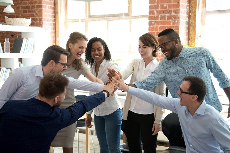 Employee Benefits - Group Of Employees Joining Their Hands Together During Meeting In The Office